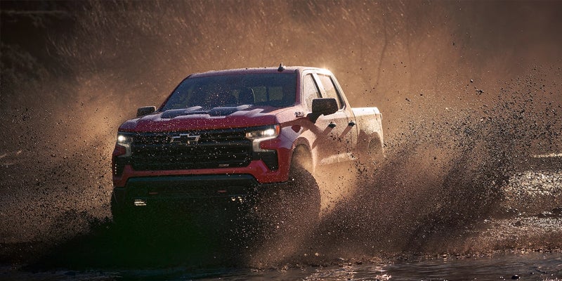 A Chevrolet Silverado 1500 drives through mud